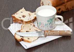 Milk cup and a piece of cake on a wooden table