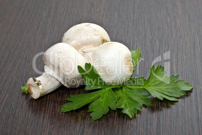 Field mushrooms with parsley on a wooden table