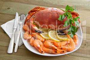 Crab with shrimp and parsley on a wooden table