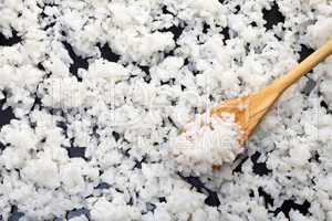 Background of boiled rice with a wooden spoon