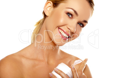 Beautiful woman applying body cream