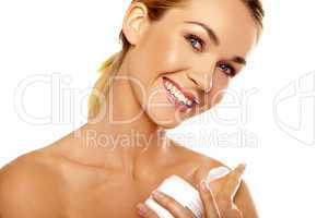 Beautiful woman applying body cream