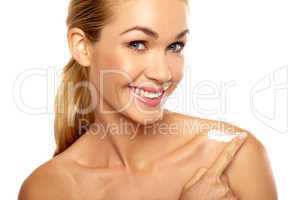 Attractive woman applying moisturiser