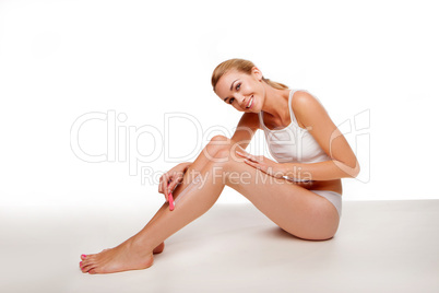 Woman sitting waxing her legs