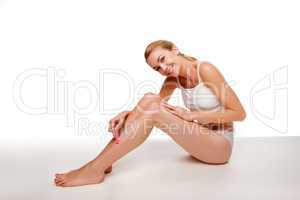Woman sitting waxing her legs