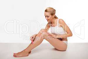Beautiful woman removing her leg hair