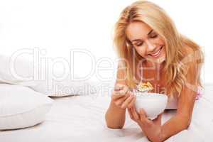Woman eating cereal in bed