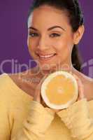 Smiling woman holding cut orange