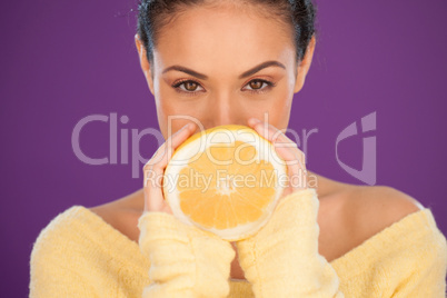 Lovely woman holding a halved orange