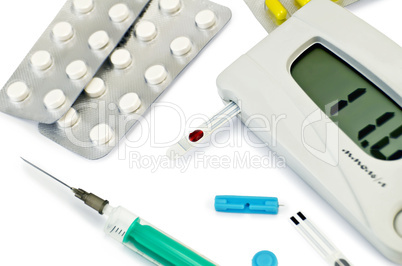 Glucometer with pills and a syringe