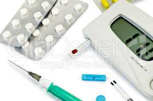 Glucometer with pills and a syringe