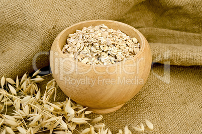 Oat flakes in a bowl on sacking