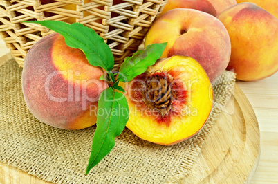 Peaches with leaves and a basket on board