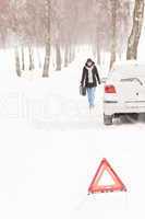 Woman walking with gas can car snow