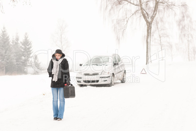 Woman walking with gas can winter car