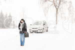 Woman walking with gas can winter car