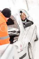 Man repairing woman's car snow assistance winter
