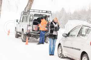 Mechanic helping woman with broken car snow