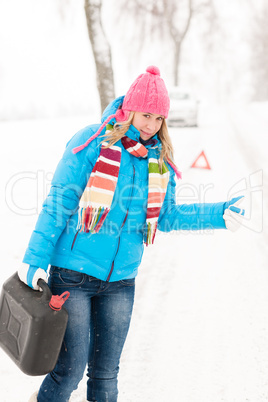 Woman hitchhiking on road snow gas can