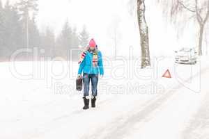 Woman carrying gas can snow car trouble