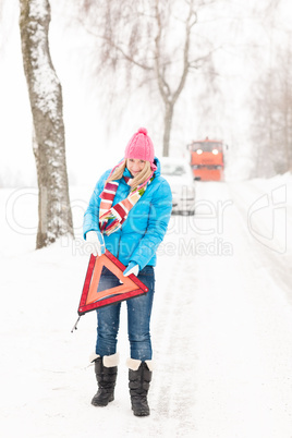 Woman with reflector triangle car snow breakdown