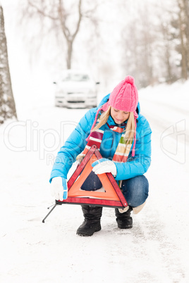 Woman put reflector triangle car breakdown winter