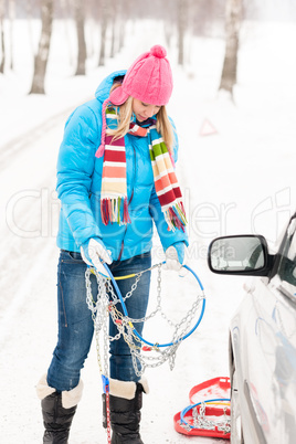 Woman snow standing with car tire chains