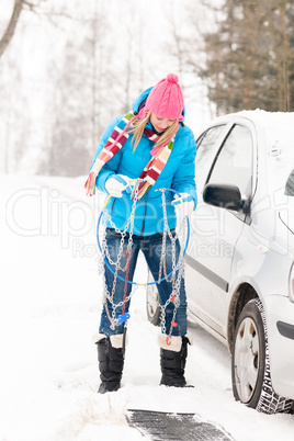 Woman having problems with car snow chains