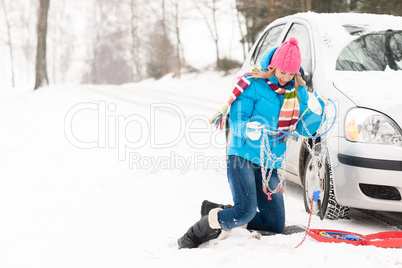 Woman with winter car tire chains snow