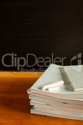 Academical notepads and chalks on wooden desk