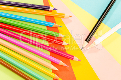 Color pencils on colorful papers close-up