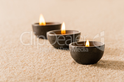 Spa therapy three candles on sand