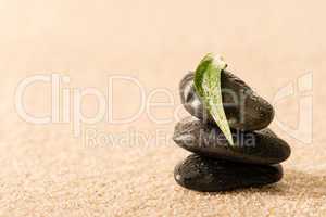 Spa zen stones with leaf on sand