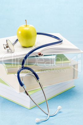 Medical books, apple and stethoscope