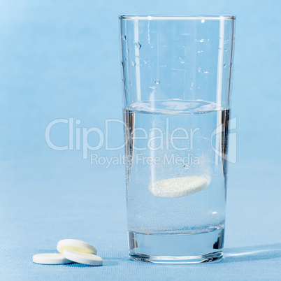 Fizzy vitamin capsule throw in water glass