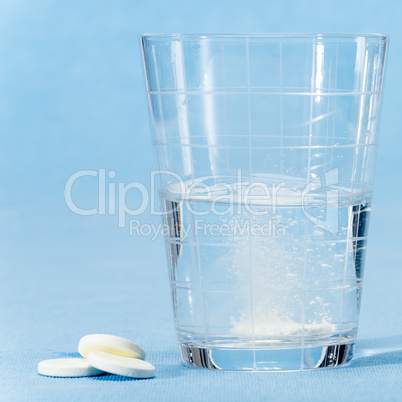 Fizzy vitamin capsule throw in water glass