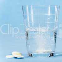 Fizzy vitamin capsule throw in water glass