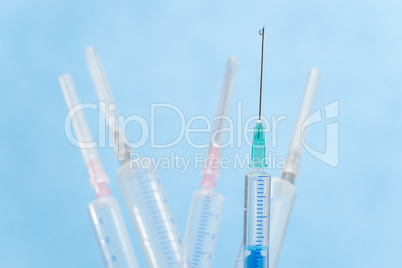 Syringes with liquid drop falling from needle