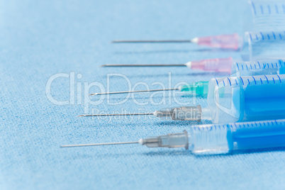 Hypodermic needles injections on blue medical cloth