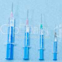 Hypodermic needles injections on blue medical cloth