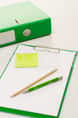 Eco business office accessories on green clipboard