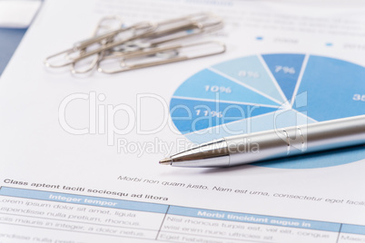 Business silver pen over office paper charts