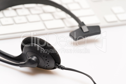 Office black headphones on white keyboard