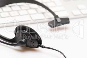 Office black headphones on white keyboard
