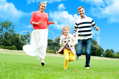 Young couple racing with their cute little daughter