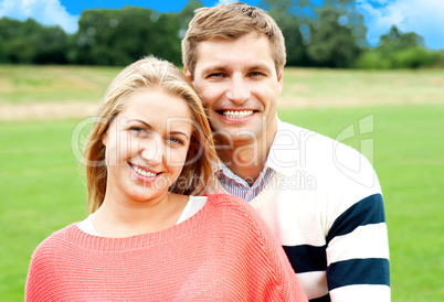 Young man standing behind his wife and hugging