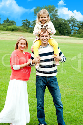 Cheerful family posing against nature background