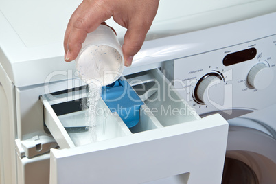 Man pours detergent into the washing machine
