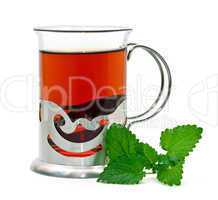 Tea in a glass holder and a sprig of lemon balm