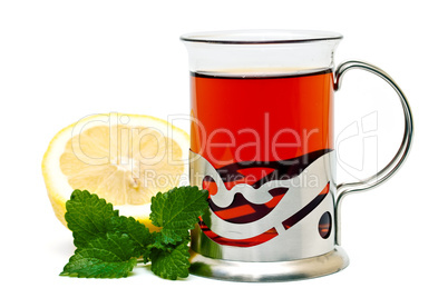 Tea in a glass holder and a sprig of lemon balm